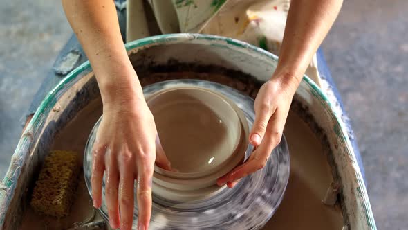 Hands of female potter making a pot