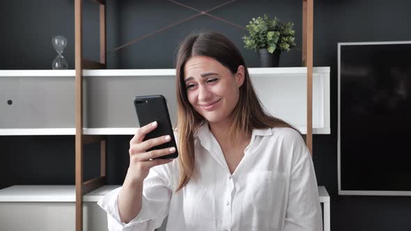 Shocked Woman in White Shirt Reading at a Loss News Opening Mouth Holding Hand Smartphone Covering