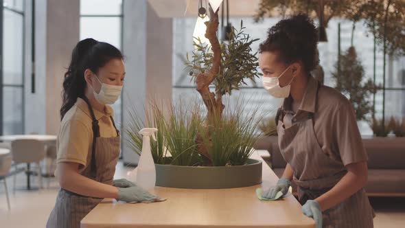 Female Cafe Workers Cleaning Table