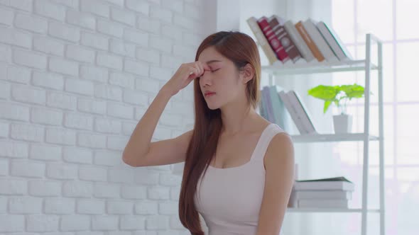 Asian young Woman has a Migraine and headache after wake up