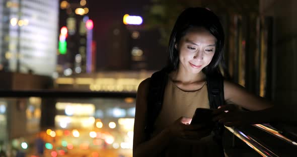 Woman use of smart phone in city at night 