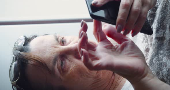 An Elderly Woman with Smartphone  She Searching Web Ang Watching Newsfeed