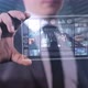 A Man Against a Background of Skyscrapers is Watching a Video on a Glass Tablet - VideoHive Item for Sale
