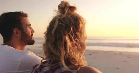 Young adult friends relaxing on the beach at sunset 4k