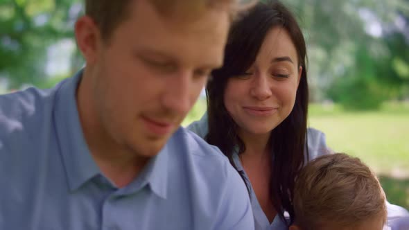 Young Couple Watching Tablet on Nature Close Up