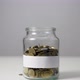 Coins in a Jar with Blank Label. Money Falling from the Sky Above in Slow Motion - VideoHive Item for Sale