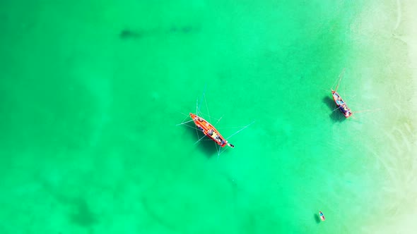 Fishing boats floating on calm water of green turquoise lagoon beautiful texture near white sandy be