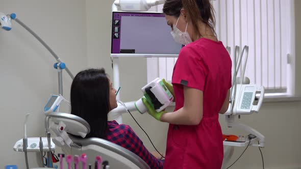 Young Female Dentist Taking Jaw Xray Using Portable Device
