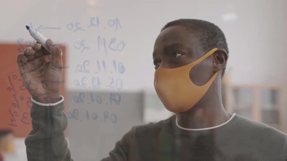 African Man Writing on Glass Board