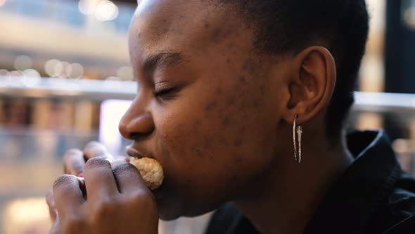 African American Young Girl Has a Huge Burger in a Cafe