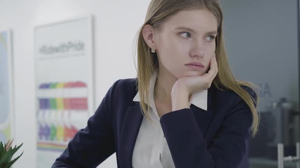 Portrait of Concerned Sad Young Lady in Formal Clothes Looking Away and Down, Thinking About Her