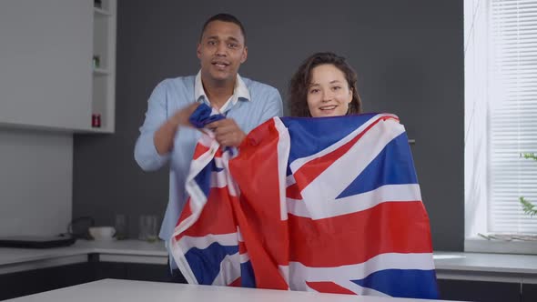 TV POV of Young Interracial Couple with British Flag Rejoicing Winning of National Team in Sports