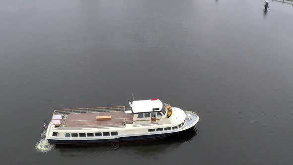 Drone pulling back on big boat on water.