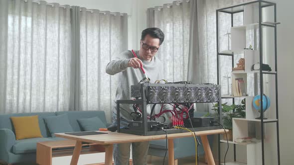 Asian Man Wearing Glasses Cleans The Mining Rig For Mining Cryptocurrency