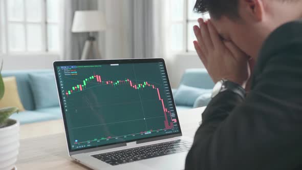 Upset Asian Businessman After Seeing Stock Prices Fall In The Trading On Computer Screen