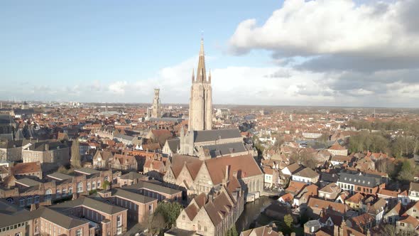 Slow reveal drone shot of Our Lady Church in Bruges Belgium on a Sunny day