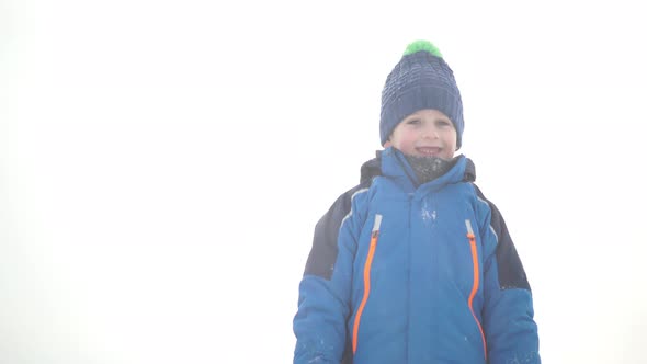 Boy Playing With Snow and Smiling