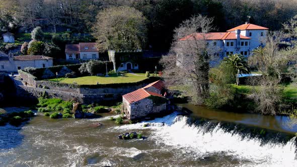 Aerial View Of Former Water Mill on the Tambre River With Water Cascading Down. Circle Dolly