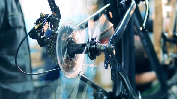 Bicycle Mechanic Testing a Rear Wheel at a Factory
