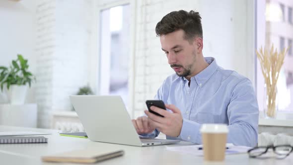 Creative Man Working on Computer and Using Smartphone