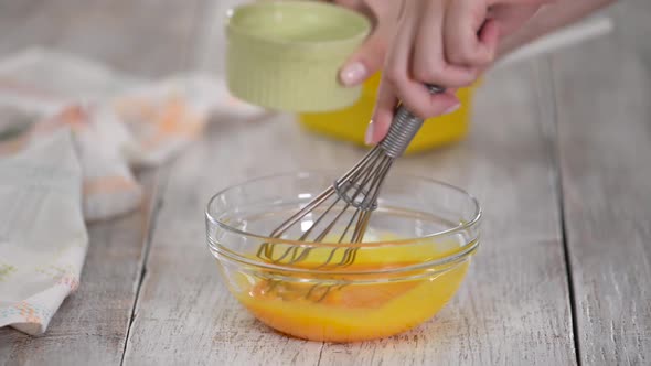 Close Up Woman Hands Beat Egg Yolks in Bowl at Kitchen