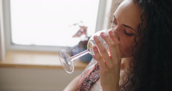 Woman drinks wine while working at home