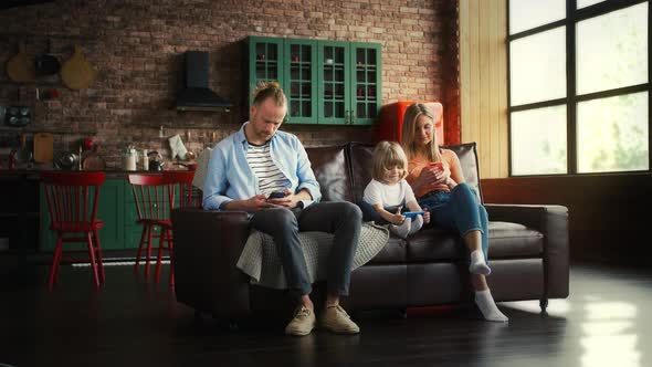 Spouses and Their Kid in Casual Outfit are Smiling Using Cellphones