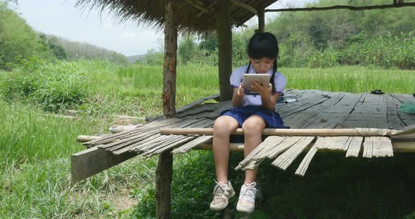Rural Little Girl Using Tablet In Cottage alt