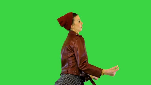 Young Girl in Stylish Urban Clothes Walks Dancing Slightly Snapping Fingers on a Green Screen Chroma