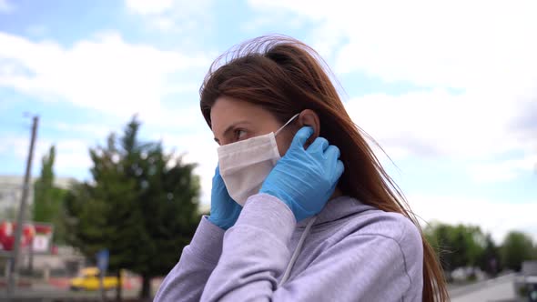 Girl in Sterile Gloves Wears a Medical Mask on Her Face