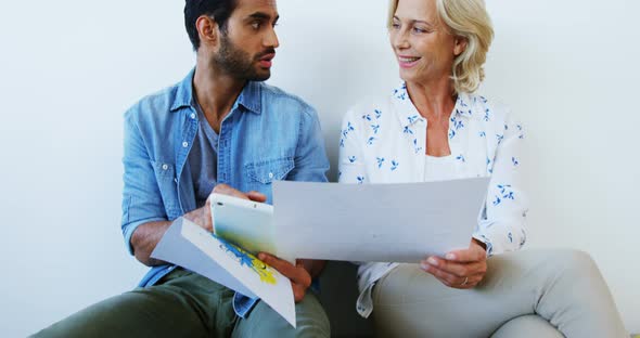 Male and female executives discussing over digital tablet