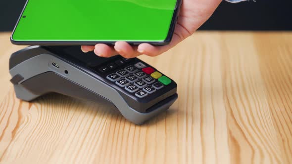 Contactless Payment with Your Smartphone with Green Mock-up Screen. Wireless Payment Concept. Close