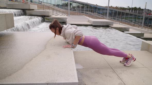 Sporty Woman is Doing Pushups in Urban Landscape Healthy Lifestyle of Townspeople