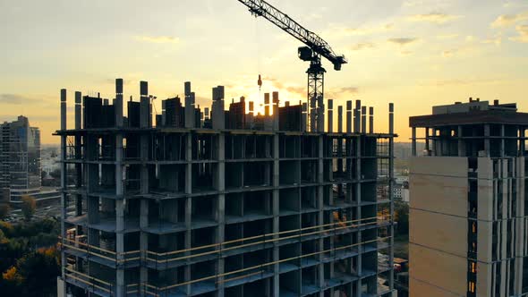 City Sunset and a Multistory House Under Construction. Aerial View of Construction Site.