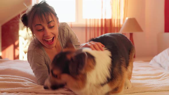 Girl Showing Dog Something Interesting at Camera Side