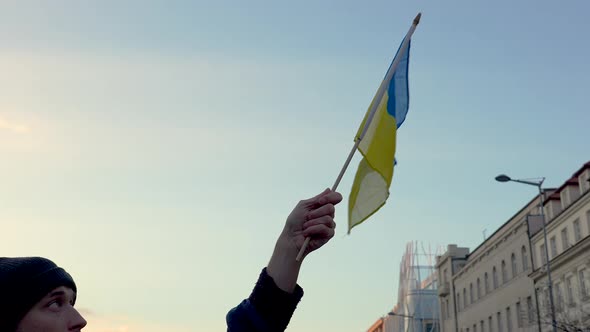 Man waving Ukrainian flag at protest against war, Prague, slow motion.