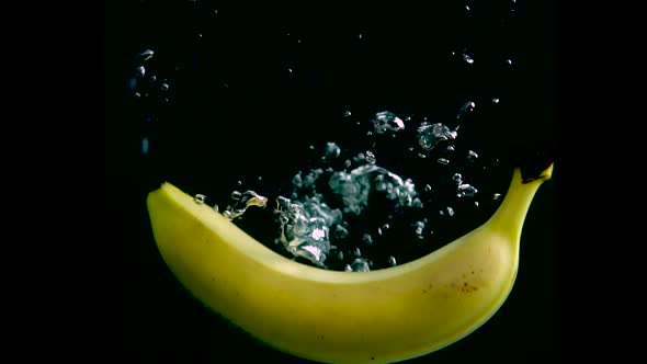 Banana Falls in the Water in Slow Motion. Isolated on Black Background with Alpha. Close Up View