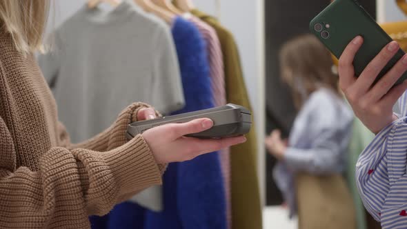 Closeup of Woman Making Payment Using Nfc in Showroom Fashion Clothes Store for Brand New Shirt and
