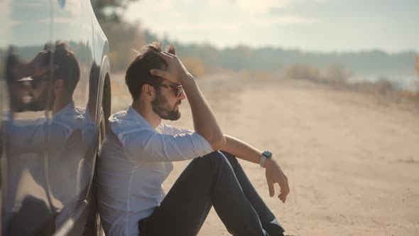 Sad Disappointed Man Sitting On Broken Car. Sad Exhausted Businessman.