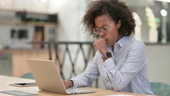 Sick African Businesswoman with Laptop Coughing in Office