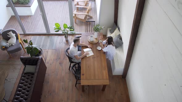 Young couple having breakfast in the kitchen