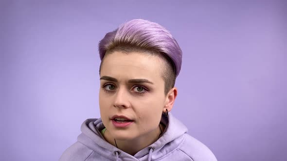 Young Woman Bringing Closer to Camera Nodding Head Violet Background