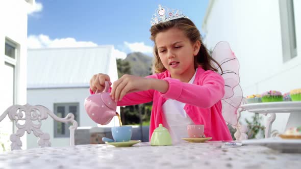 Girl in fairy costume pouring tea into cup 4k