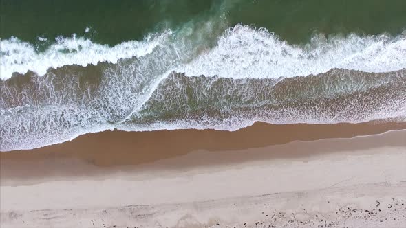 Aerial view of waves splashing onto the beach