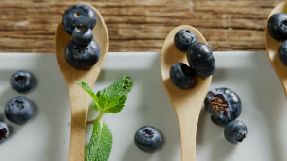 Spoons of blueberries with mint arranged on tray table 4k