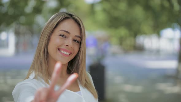 Happy Young Woman Showing Victory Sign