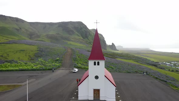 Church in Vik, Iceland with green monitions with drone video pulling out.