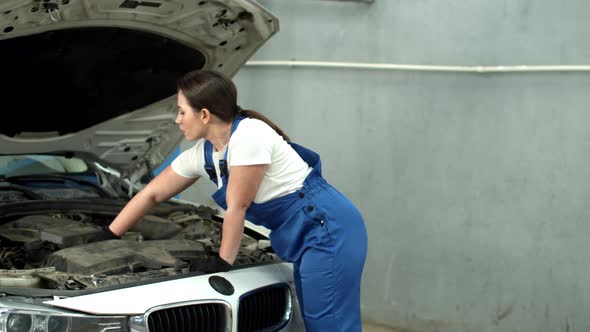 Woman Mechanic Repairs a Car in Car Service