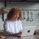 Young Redhaired Woman with Curly Hair Sitting at Home Kitchen Getting and Reading Congratulations - VideoHive Item for Sale