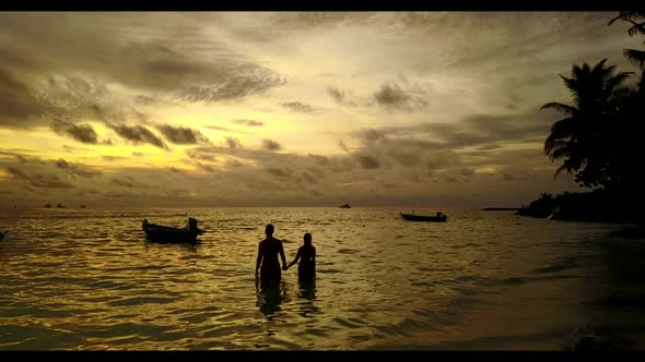 Family of two in love on paradise tourist beach voyage by turquoise water with bright sandy backgrou